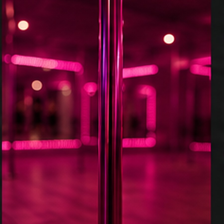 Detalle de un tubo de Pole Fitness con luces rosas